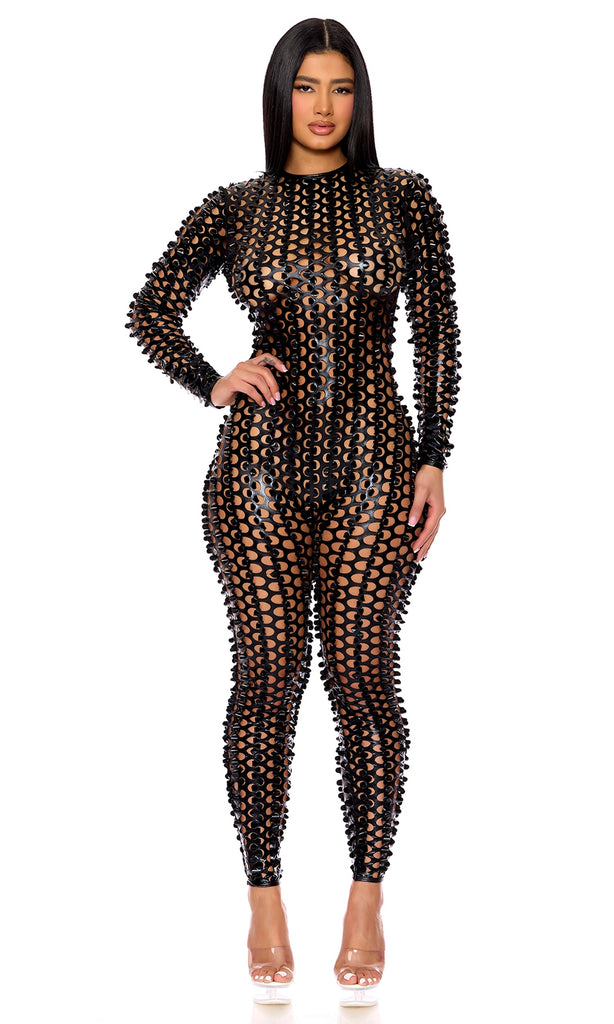 Woman wearing Bold Black Cut-Out Jumpsuit with lasercut holes and mockneck, showcasing a back zip design, highlighting bold and fashionable style.