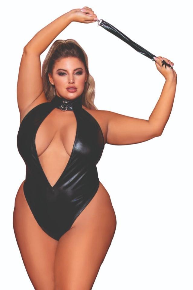 Woman in Plus Size Studded Faux-Leather Teddy with Flogger, showcasing its plunging neckline, studded collar, and adjustable waist elastic, embodying confidence and fierceness.