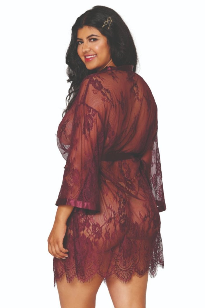 A woman with long dark hair and a hairpin is modeling the Playful Curvy Eyelash Lace Scallop Robe. This sheer maroon lace robe features satin banding details, an attached belt closure, floral patterns, mid-thigh length, and three-quarter length sleeves. She is smiling and has one hand on her hip.