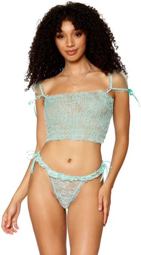 Woman modeling the Mint Delight Lace Smocking Camisole and Thong Set, featuring lace details, satin bow accents, and cap sleeves, creating a playful and flirty look.