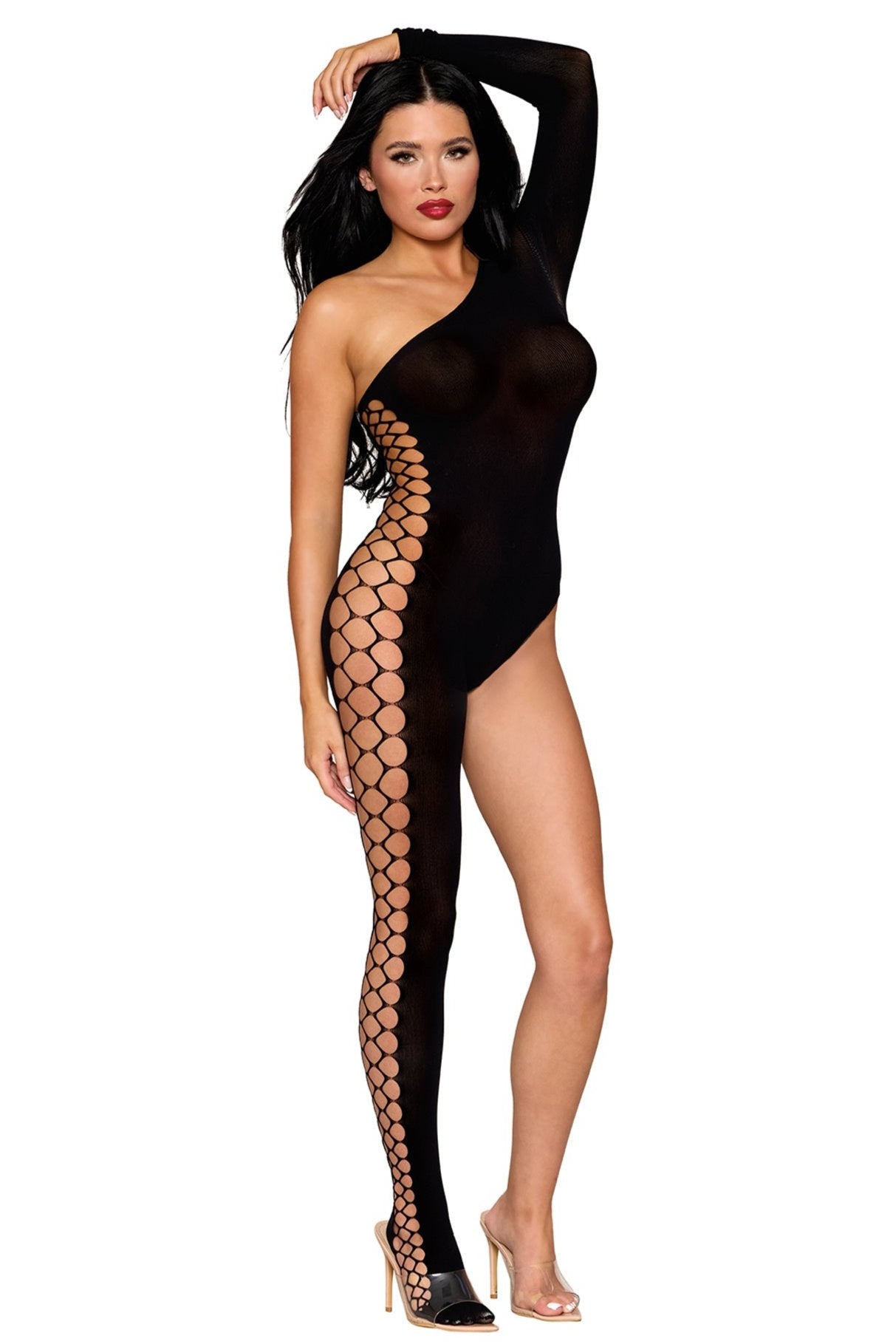 A woman poses in the One Leg Cut Out Bodystocking, a striking black asymmetrical piece with one long sleeve on the right and a full-length leg on the left. The design is accentuated by an array of circular cut-outs adorning the left leg. She has dark hair and pairs the outfit with clear high-heeled shoes.